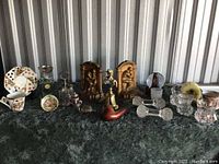 Wide shot of all decorative items including bookends, crystal decanter, salt and pepper shakers, ceramic plates and bowls.