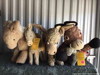 Front view of four mohair donkey plush toys showing different sizes and colors