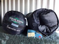 Photo showing two black Europe Bound Travel Outfitters sleeping bags packed in stuff sacks with Superlite -10°C label visible.