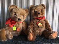 Two Hermann Teddy Original bears sitting side by side with red ribbons and tag visible