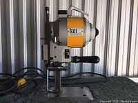 Side view of KM electric cloth cutting machine showing overall structure and handle.