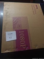 Box of BenQ W1000+ projector showing brand, model and 1080P resolution.