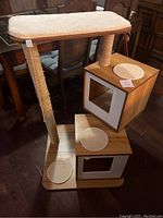 Full view of cat stand showing two boxes with padded tops, vertical scratching posts, and base with circular scratch pads.