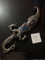 Blade with detailed dragon design handle and matching sheath showcasing blue accents.