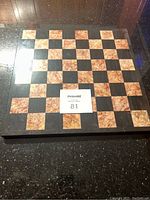 Top view of the full square granite chess board showing the alternating black and pink granite squares in an 8x8 pattern.