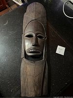 Front view of the large African hardwood mask showing carved facial features and wood cracks.