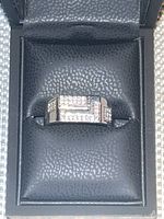 Front view of silver men's ring showing geometric arrangement of diamond-colored stones embedded on the top of the band.