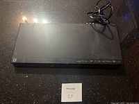 Top view of black Sony BDP-BX85 Blu-ray player showing slim rectangular unit with power cord attached.