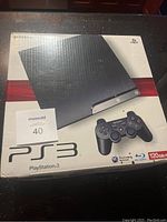 Photo of the Sony PS3 Slim 120GB console box with device and controller image.
