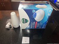 Vicks Warm Steam Vaporizer displayed next to its original box on a kitchen counter.