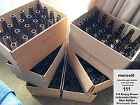 Cardboard boxes holding multiple brown refillable soda/beer bottles, arranged for storage and transport.