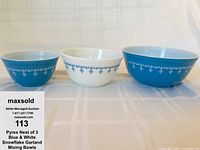 Front view of three nesting Pyrex mixing bowls showing snowflake pattern and color contrast