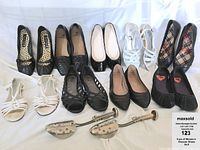 Overview of nine pairs of women's size 8 shoes in black and white, two metal shoe stretchers, and a three-tier metal shoe rack.