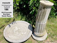 Concrete bird bath base and basin top separated on grass, showing condition and pieces for repair.