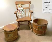 Full view of child's light wood rocking chair with porcelain doll seated on chair and two wooden firkin buckets placed nearby.