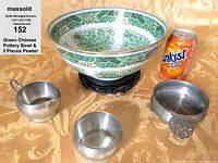 Photo of green Chinese porcelain bowl on wooden stand with three pewter pieces and orange soda can for scale.