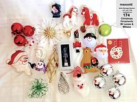 Top view showing assorted Christmas ornaments on white background including red, silver baubles, Santa, snowman, nutcracker, decorative baubles and boxed items.