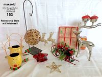 Photo showing entire lot including multiple reindeer candles and figurines, star-shaped ornaments, sled with greenery and candle holders.