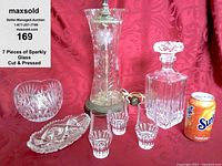 Full view of all 7 glass items including cut glass vase lamp, decanter, bowl, relish dish, and 3 aperitif glasses with soda can for scale.