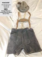 Gray leather lederhosen with suspenders laid flat on white surface