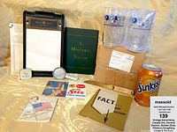 Photo showing open table with GE clipboard, booklet, glasses, cards, and soda can for scale
