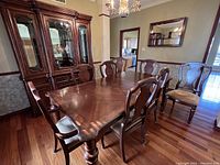 View of dining table with eight chairs in room, hutch visible behind