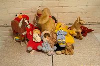 Collection of children's toys including Elmo, horse plush, stuffed dog, and various dolls.