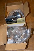 Two Dorex FH Series door lock handles in original boxes, partially unpacked, showing satin chrome finish and included locksets.