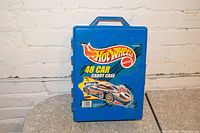 Blue Hot Wheels 48 car carry case closed showing front artwork and logo.