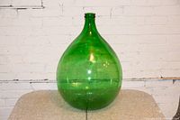 Full view of the large green glass jug showing its teardrop shape and smooth surface.
