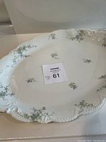 Top view of oval porcelain platter showing blue floral pattern and scalloped edge