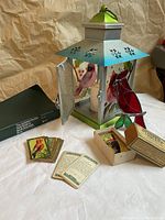 Front and side view of bird-themed battery operated lantern, vintage bird cards, and green box