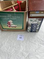 View of the boxed kneeling Santa figurine and boxed Dansk glassware