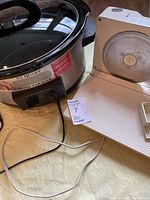 Photo showing Waring slow cooker with ceramic pot and glass lid beside Krups food slicer.