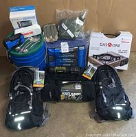 Overview of entire lot showing backpacks, stove, bucket, tarps, blankets and accessories