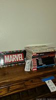 Marvel books stacked with a Marvel plastic license plate frame on the left