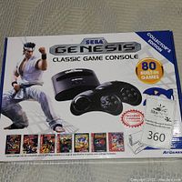 Box front showing Sega Genesis Classic Game Console branding, collector's edition, and 80 built-in games, with image of two controllers and a character.