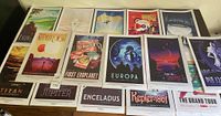 Fifteen posters laid out in two rows on table, showing planetary and exoplanet titles