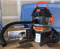 Kubota mini shop vacuum with hose and nozzle attachments alongside Krieger 1100-watt 12V inverter in original box, item tag 226 visible.