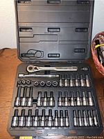 Open Craftsman socket wrench set case showing ratchet wrench and multiple sockets arranged in rows with extension bars.