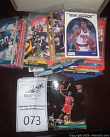 Various sports trading cards including basketball and football, showing Michael Jordan, Troy Aikman, Kevin Johnson and others.