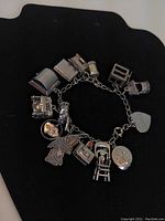 Overall view of the sterling silver charm bracelet showing all its linked charms on a chain.