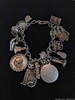 Full view of the sterling silver charm bracelet displaying all attached charms and the clasp.