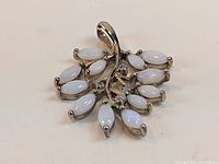 Front view showing the marquise-shaped opal stones and clear stones on the gold plated sterling silver pendant.