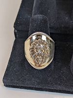Front view of ring displaying raised gold plated lion head on sterling silver band