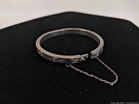 Image showing clasp and safety chain attached to sterling silver hinged bracelet
