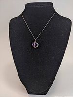 Necklace displayed on a black bust stand, showing chain length and pendant placement.