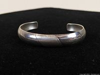 Front view of sterling silver cuff bracelet showing alternating polished shiny and buffed matte silver bands.