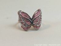 Front view of the rose gold plated butterfly ring showing pink enamel wings with clear stones.