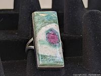 Close-up front angle of the Southwestern sterling ring showing the multicolored green, purple, and white stone and silver setting.